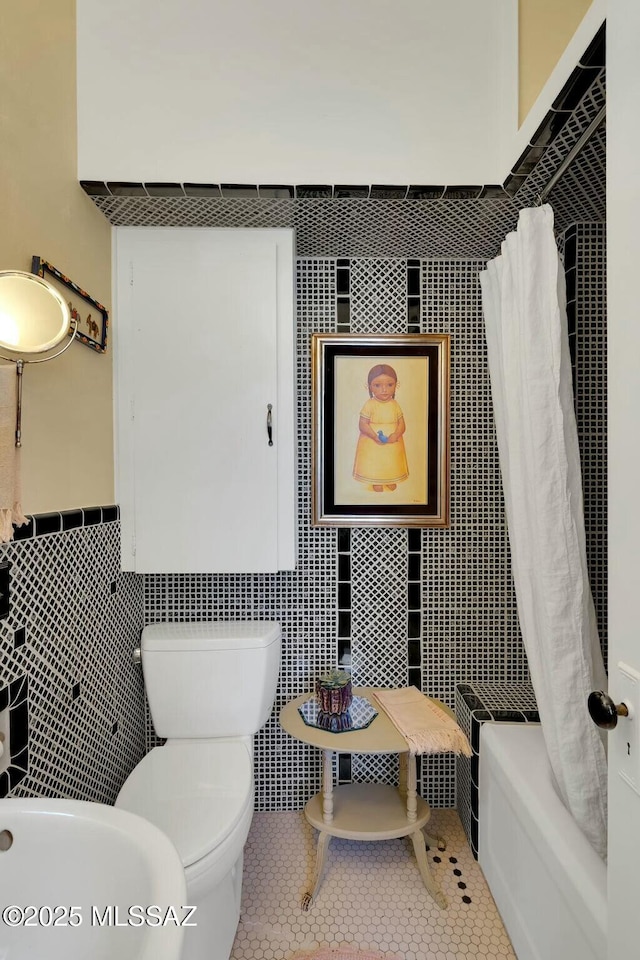 bathroom featuring shower / bath combo, tile walls, toilet, and tile patterned floors