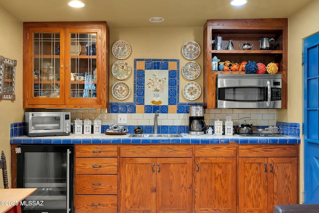 bar with wine cooler, a sink, stainless steel appliances, backsplash, and recessed lighting