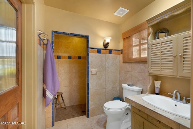 bathroom featuring a walk in shower, tile patterned flooring, toilet, visible vents, and tile walls