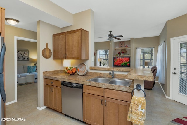 kitchen with light tile patterned flooring, dishwasher, a peninsula, and a sink