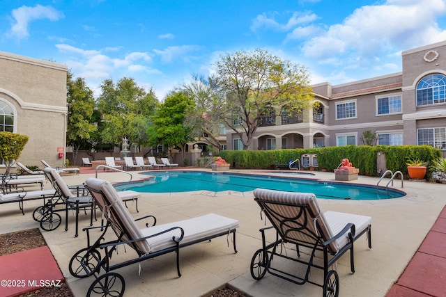 community pool featuring fence and a patio