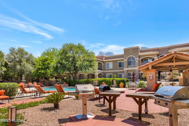 view of community with a swimming pool, fence, and a patio