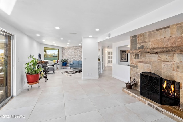 living area featuring visible vents, baseboards, light tile patterned flooring, a fireplace, and recessed lighting