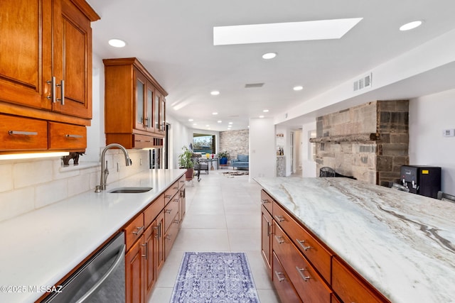 kitchen featuring tasteful backsplash, visible vents, dishwasher, open floor plan, and a sink