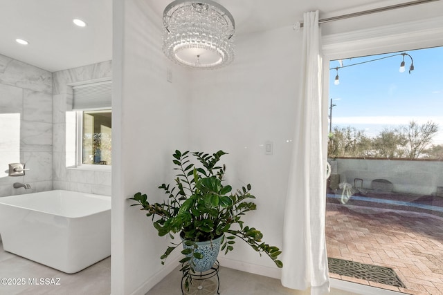 full bathroom with a freestanding bath, recessed lighting, baseboards, and a healthy amount of sunlight