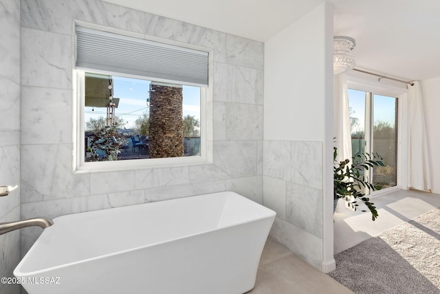 full bath featuring a soaking tub and tile walls