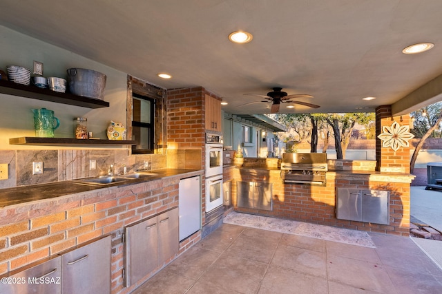 view of patio with a sink, area for grilling, a grill, and a ceiling fan