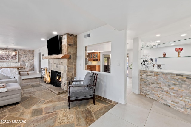 living area featuring a bar, a fireplace, visible vents, and recessed lighting