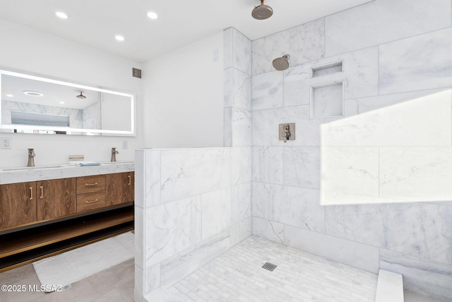 full bathroom featuring recessed lighting, tiled shower, a sink, and double vanity