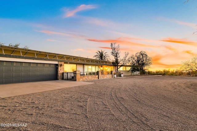 view of front facade featuring a garage, concrete driveway, and stone siding