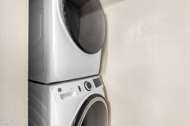 washroom featuring stacked washer and dryer and laundry area