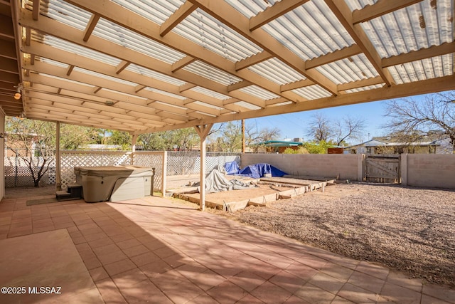 view of patio / terrace with a fenced backyard, a gate, and a hot tub