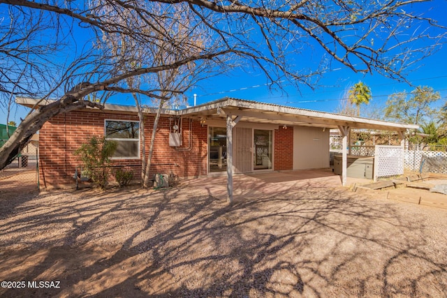 back of house featuring brick siding, a patio, and fence