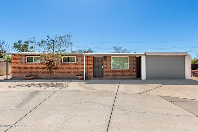 ranch-style house featuring a garage, brick siding, and driveway