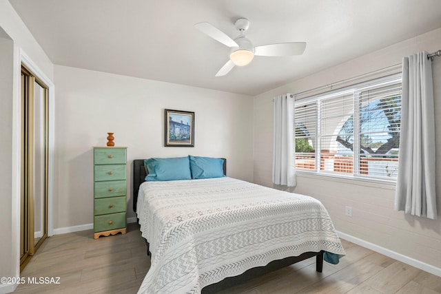 bedroom featuring a ceiling fan, light wood-type flooring, and baseboards