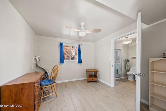 office space with baseboards, ceiling fan, and light wood finished floors