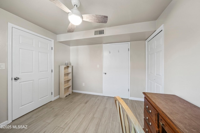 unfurnished bedroom with a ceiling fan, baseboards, visible vents, and light wood finished floors