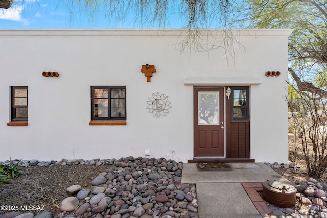 view of exterior entry featuring stucco siding