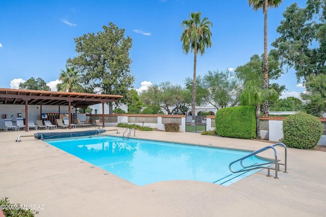 pool with a patio area and fence