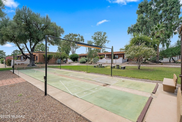 view of property's community with shuffleboard and a lawn