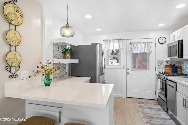 kitchen with light wood finished floors, decorative backsplash, a peninsula, stainless steel appliances, and open shelves