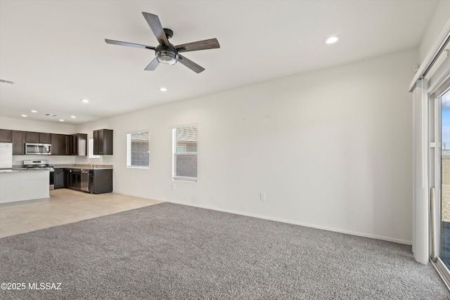 unfurnished living room with recessed lighting, light colored carpet, visible vents, ceiling fan, and baseboards