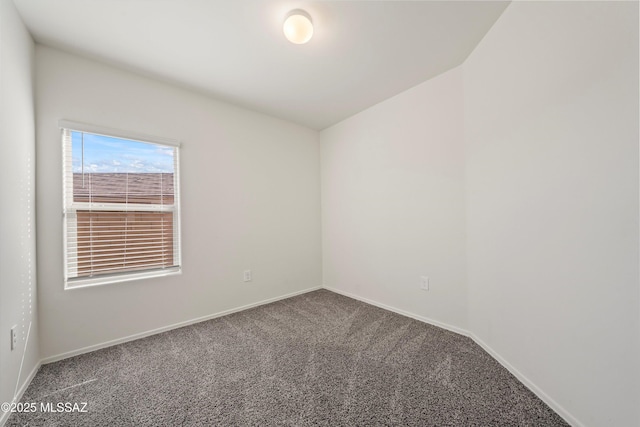 carpeted empty room featuring baseboards