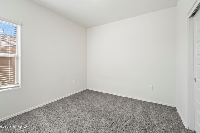 spare room featuring carpet flooring and baseboards