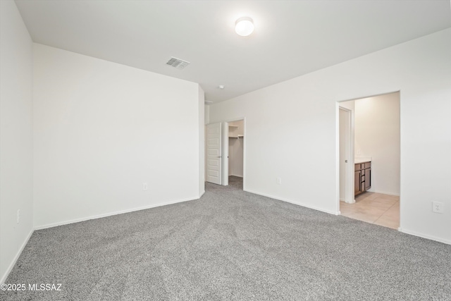 empty room featuring light carpet, baseboards, and visible vents