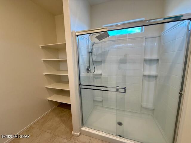 full bathroom with a stall shower and tile patterned flooring