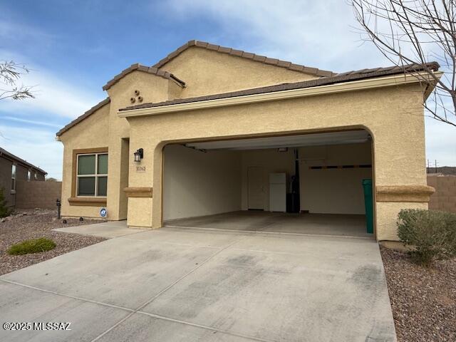 mediterranean / spanish house featuring a garage, driveway, fence, and stucco siding