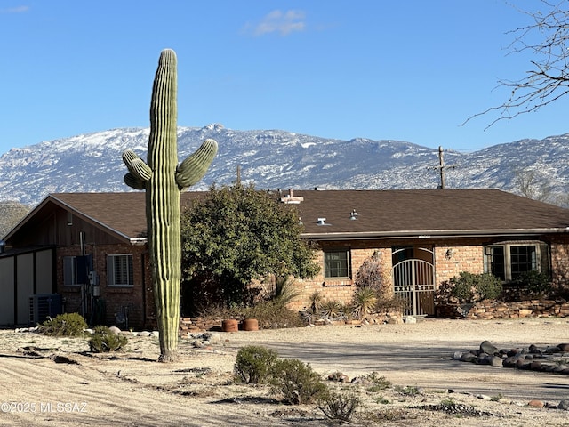 view of front of house with a mountain view, cooling unit, and brick siding