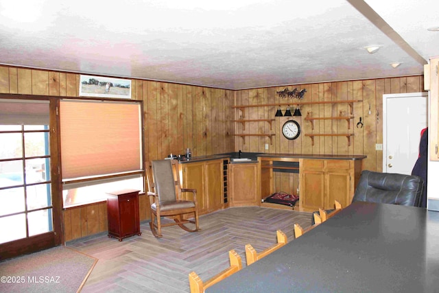 bar featuring wood walls and a textured ceiling