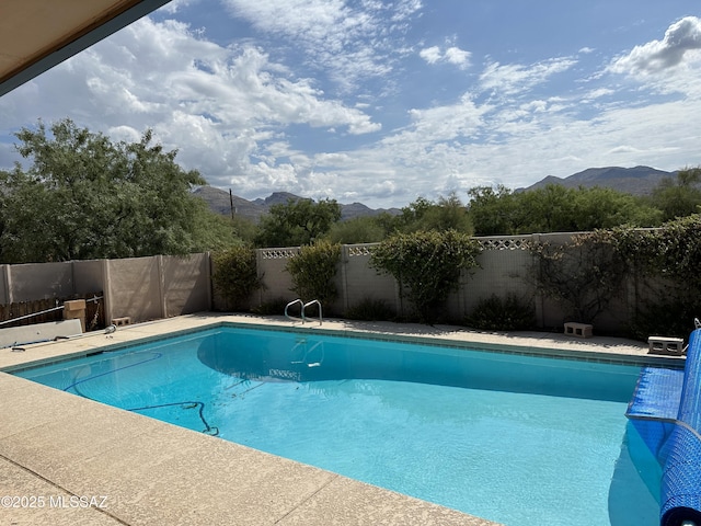 view of swimming pool with a fenced in pool, a fenced backyard, and a mountain view