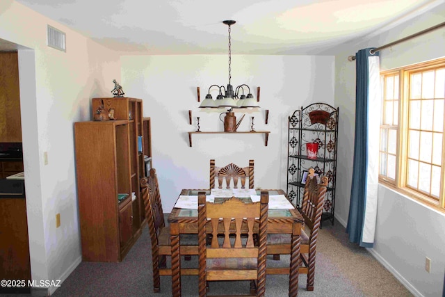 dining room with plenty of natural light, carpet flooring, visible vents, and an inviting chandelier