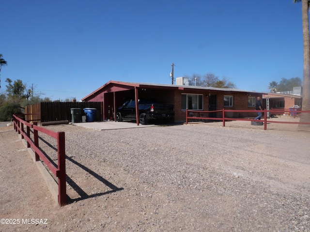 ranch-style home featuring driveway, an attached carport, and brick siding