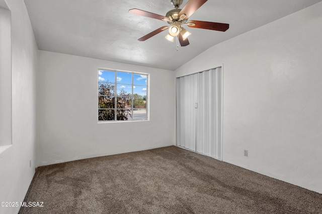 unfurnished bedroom featuring vaulted ceiling, a closet, carpet, and a ceiling fan