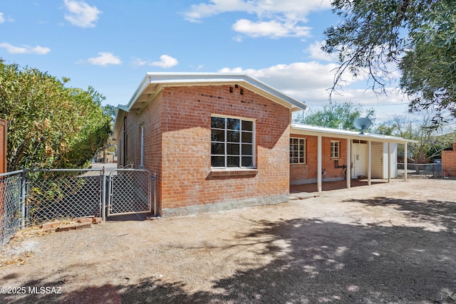 view of front facade featuring brick siding, fence, and a gate