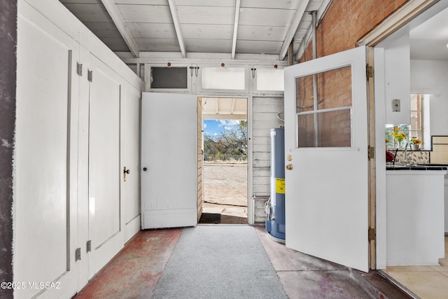 entryway featuring water heater and unfinished concrete floors