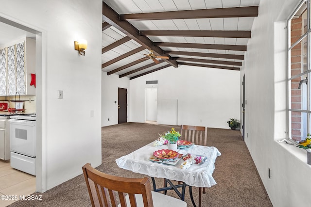 dining space featuring lofted ceiling with beams, light carpet, and a ceiling fan