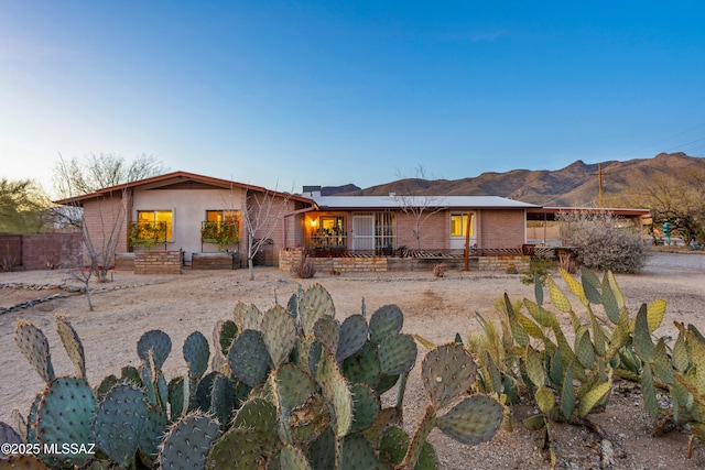 view of front of home featuring a mountain view and fence