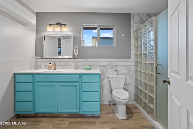 full bathroom with toilet, wood finished floors, vanity, tile walls, and a wall mounted AC