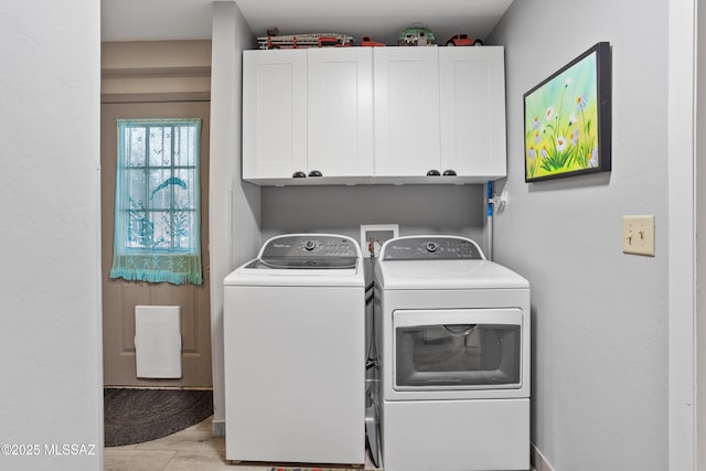 laundry area with light wood-type flooring, cabinet space, and separate washer and dryer