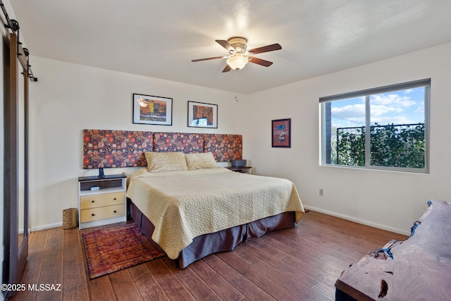 bedroom featuring a barn door, baseboards, ceiling fan, and hardwood / wood-style floors