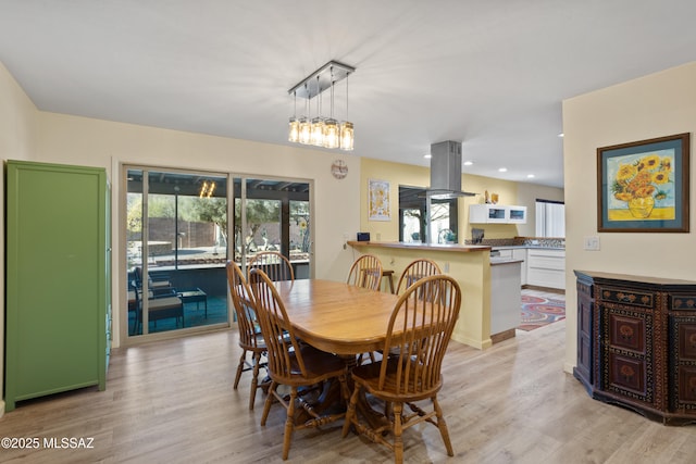 dining area with light wood-type flooring and recessed lighting