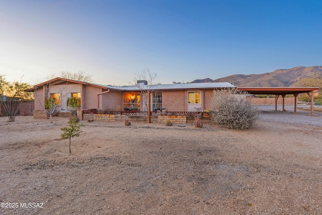 view of front of property with an attached carport, brick siding, and driveway