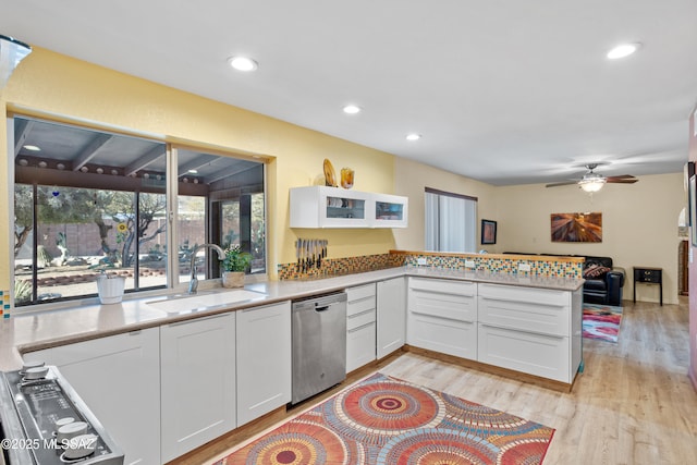 kitchen featuring a sink, white cabinetry, light wood-style floors, light countertops, and stainless steel dishwasher