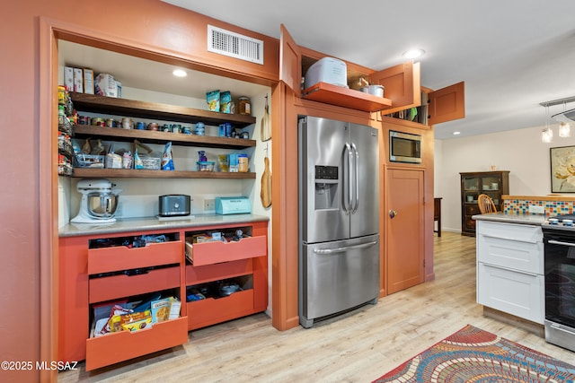 kitchen with visible vents, light countertops, appliances with stainless steel finishes, light wood-type flooring, and open shelves