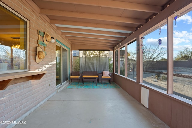 unfurnished sunroom featuring beam ceiling