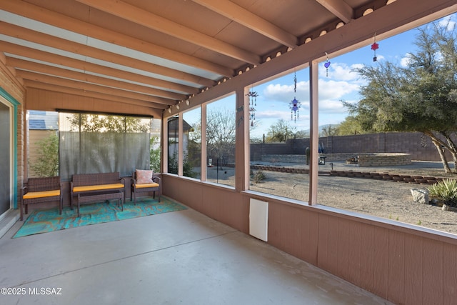 unfurnished sunroom with beamed ceiling